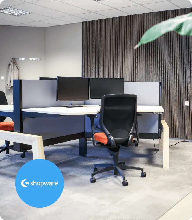 Een werkplek op het kantoor van Miller Digital, met het Shopware-logo